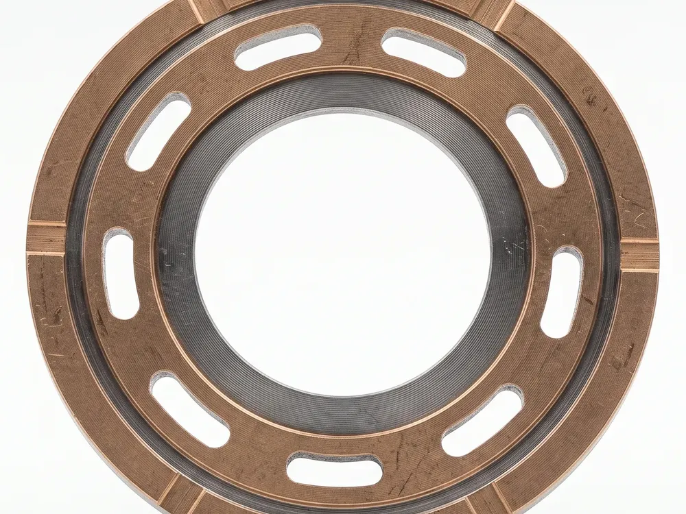 Plato de bronce de una Sundstrand Serie 20: disco con cara de bronce, ranuras alargadas en círculo para el paso del aceite y centro de acero